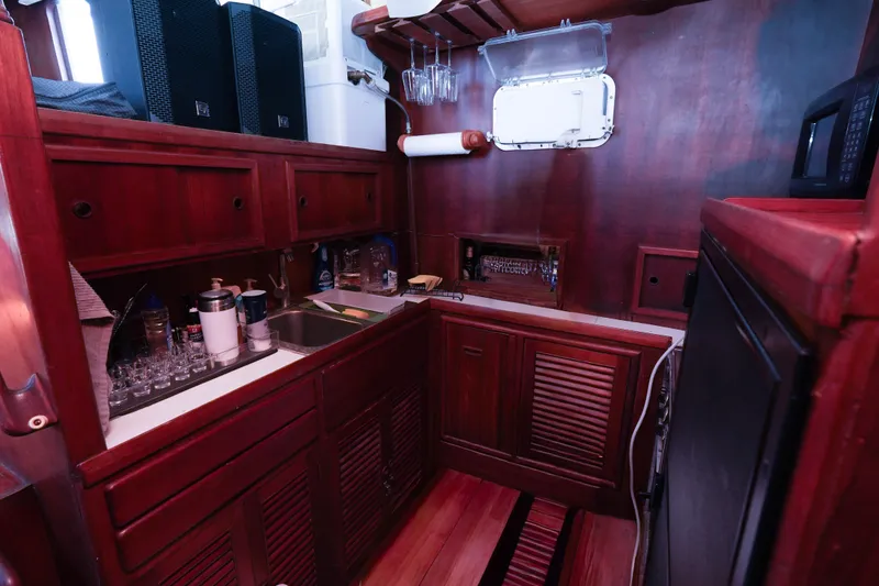 Slide: The Image of Interior of 1982 CHB Classic Trawler 41, featuring a compact wooden kitchen area. - 18