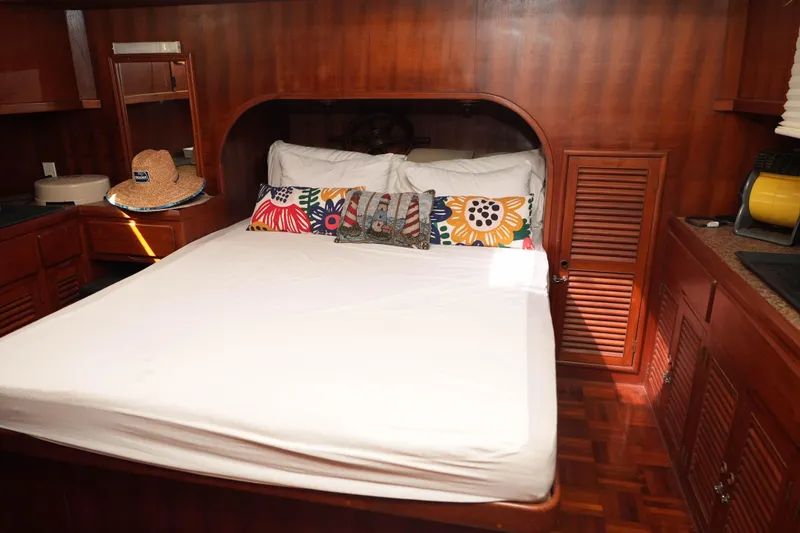 Slide: The Image of Cozy bedroom in 1982 CHB Classic Trawler 41 with wooden interior and colorful pillows. - 19