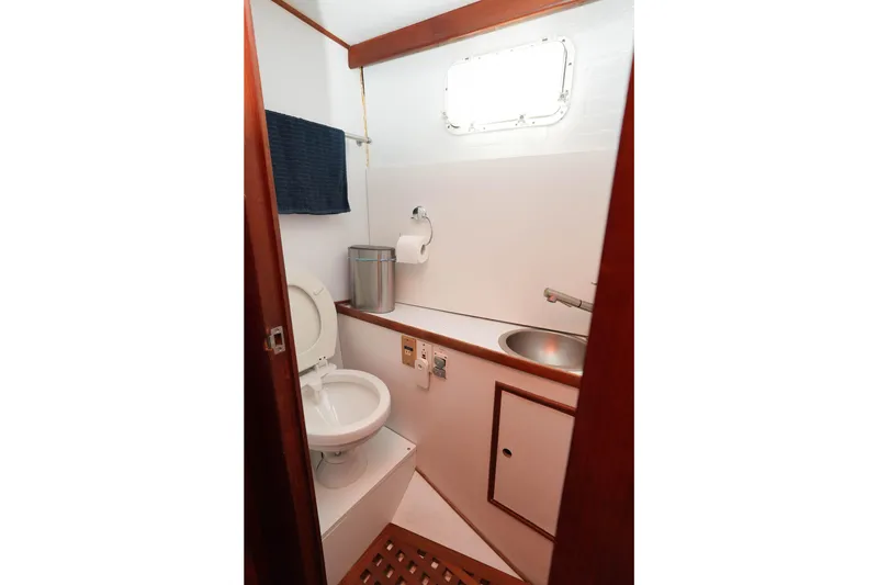 Slide: The Image of 1982 CHB Classic Trawler 41 bathroom with toilet, sink, and wooden accents. - 25