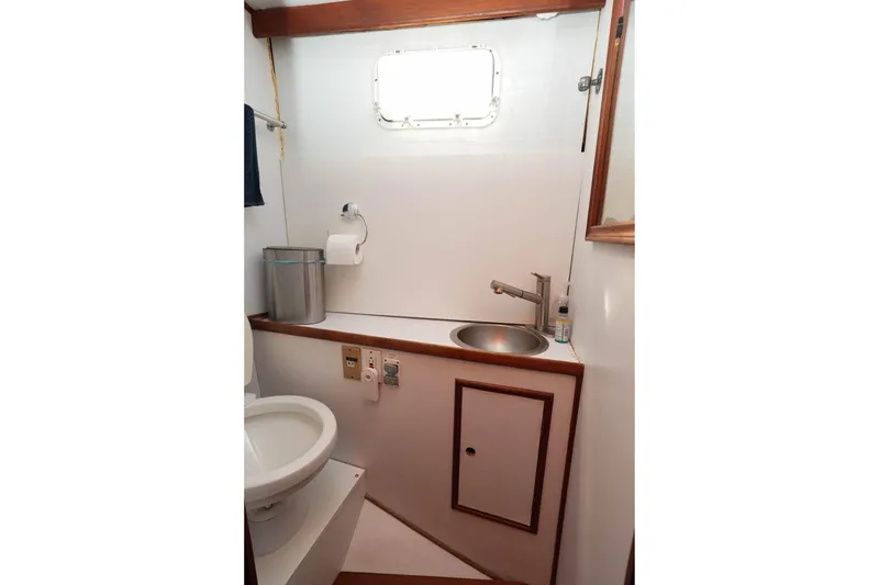 Slide: The Image of 1982 CHB Classic Trawler 41 bathroom with sink, toilet, and porthole window. - 27