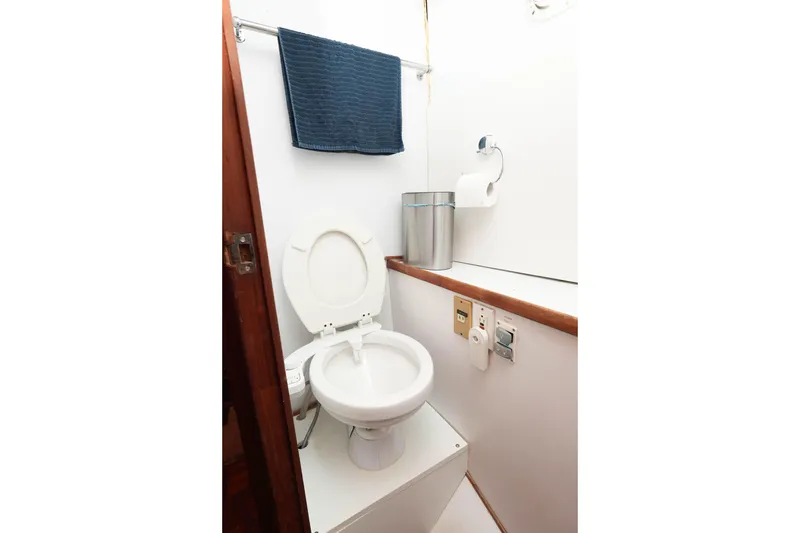 Slide: The Image of 1982 CHB Classic Trawler 41 bathroom with toilet, towel, and waste bin. - 28