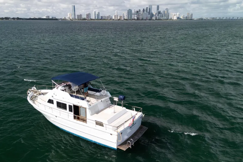 Slide: The Image of 1982 CHB Classic Trawler 41 cruising near city skyline on open water. - 3