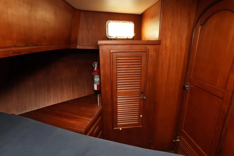 Slide: The Image of 1982 CHB Classic Trawler 41 interior with wooden cabinetry and a fire extinguisher. - 30