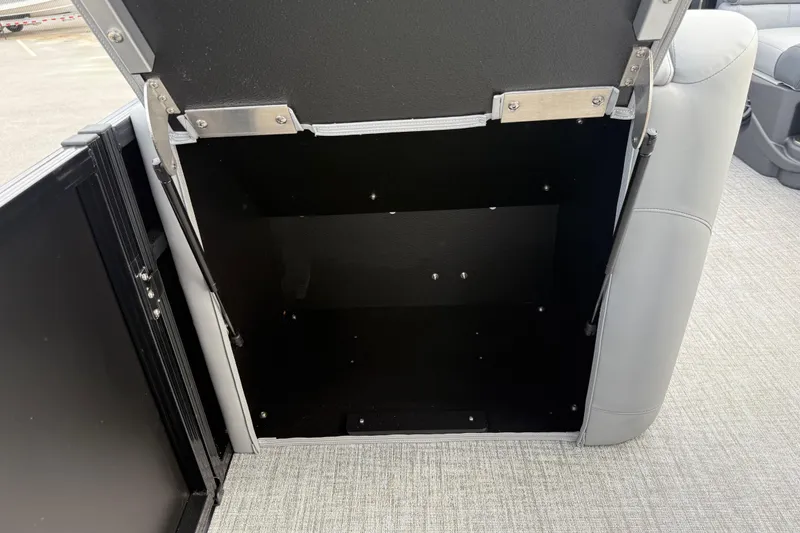 Slide: The Image of Open storage compartment in 2026 Avalon LSZ Rear Fish boat, featuring gray upholstery. - 33