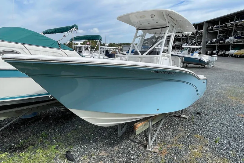 Slide: The Image of 2022 Sea Fox 228 Commander boat in a marina, light blue hull, parked on gravel. - 3