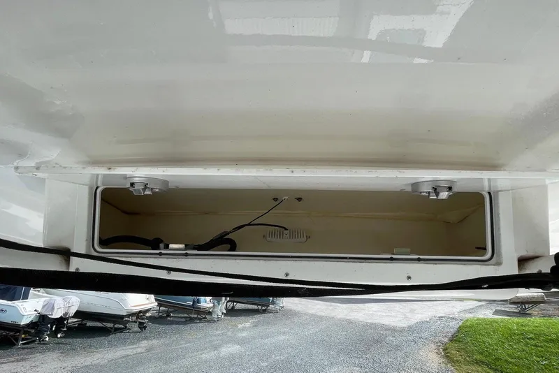 Slide: The Image of 2022 Sea Fox 228 Commander storage compartment, open and empty, with visible wiring inside. - 30