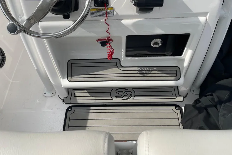 Slide: The Image of 2022 Sea Fox 228 Commander boat helm with steering wheel and storage compartment. - 53