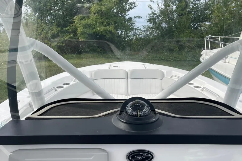 Slide: The Image of 2022 Sea Fox 228 Commander boat interior with compass and seating, surrounded by greenery. - 72