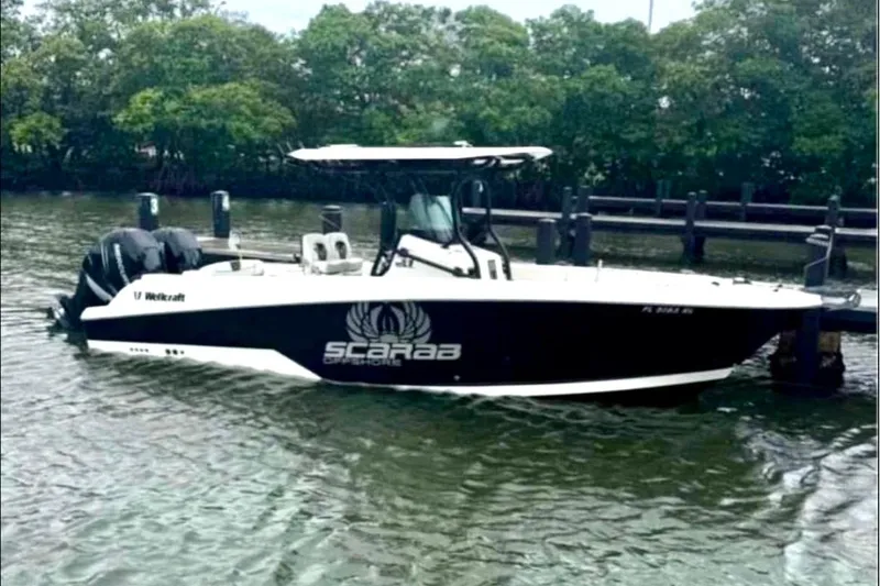 Slide: The Image of 2017 Wellcraft 262 Scarab Offshore boat docked on calm water. - 0