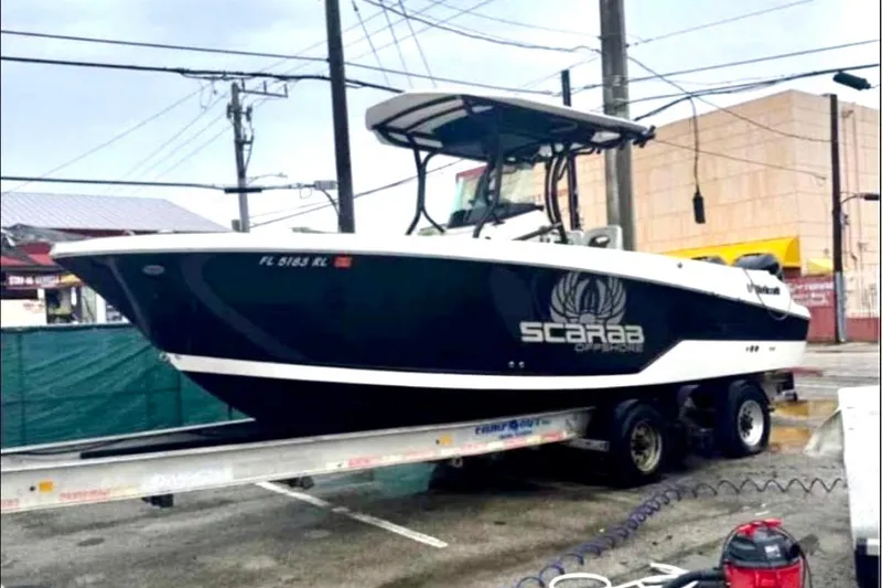 Slide: The Image of 2017 Wellcraft 262 Scarab Offshore boat on trailer in urban setting. - 2
