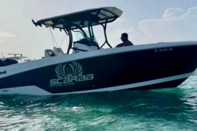 Slide: The Image of 2017 Wellcraft 262 Scarab Offshore boat on water, side view with logo visible. - 3