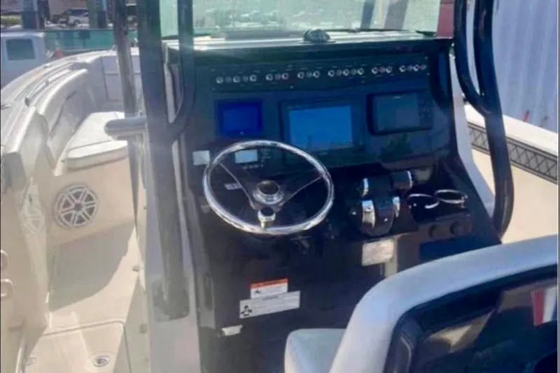 Slide: The Image of 2017 Wellcraft 262 Scarab Offshore boat dashboard with steering wheel and controls. - 8