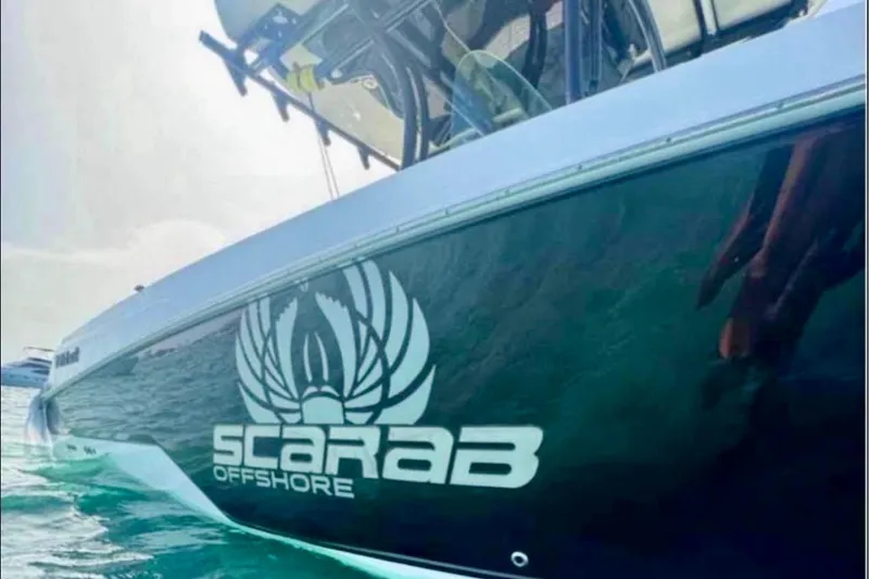 Slide: The Image of 2017 Wellcraft 262 Scarab Offshore boat on water, showcasing sleek design and logo. - 9