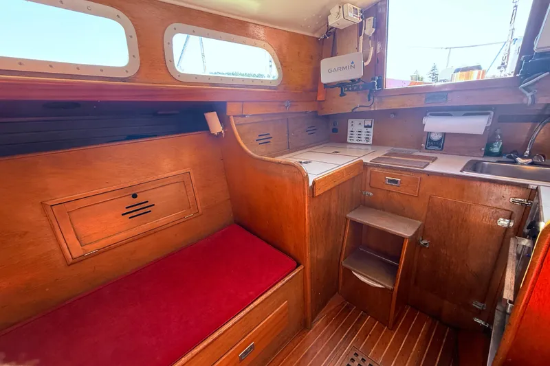Slide: The Image of 1970 Hinckley Pilot 35 yacht interior with wooden cabinetry and red seating. - 6