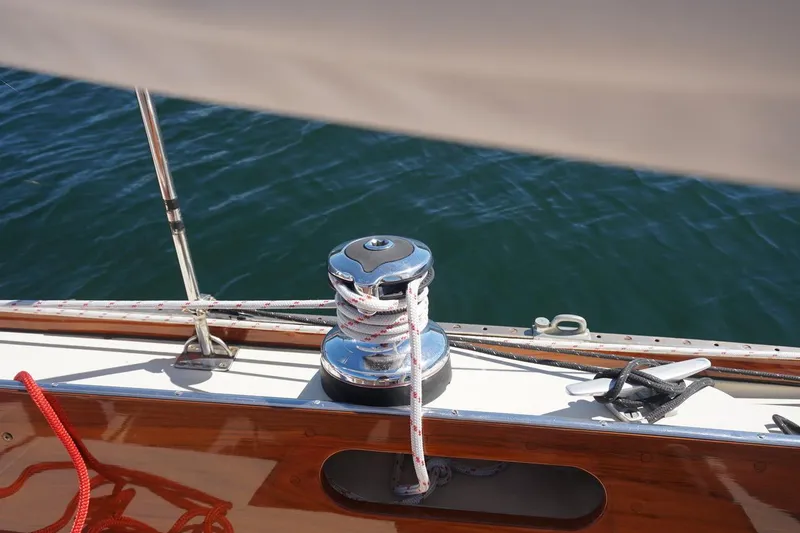 Slide: The Image of 1970 Hinckley Pilot 35 sailboat deck with winch and ropes on water. - 4
