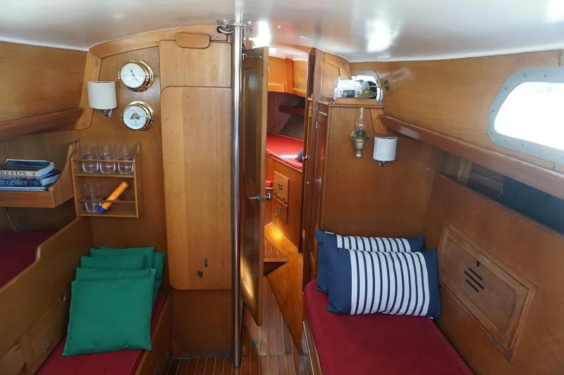 Slide: The Image of Interior of a 1970 Hinckley Pilot 35 sailboat with wooden furnishings and cozy seating. - 5
