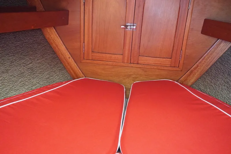 Slide: The Image of Interior of 1970 Hinckley Pilot 35 sailboat with red cushions and wooden cabinetry. - 8