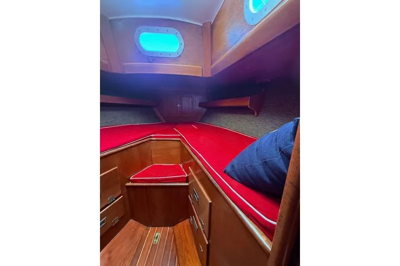 Slide: The Image of Interior of 1970 Hinckley Pilot 35 sailboat with red cushions and wooden cabinetry. - 9