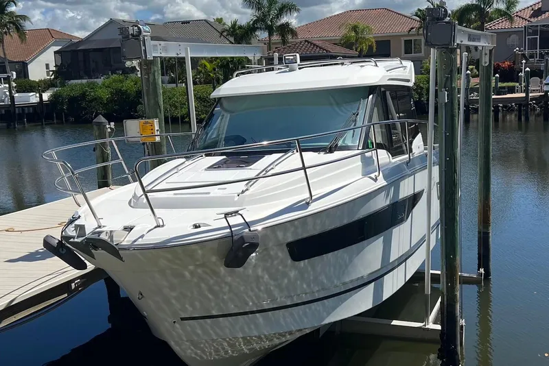 The Image of 2024 Jeanneau NC Weekender 895 boat docked in a scenic waterfront setting. - 0