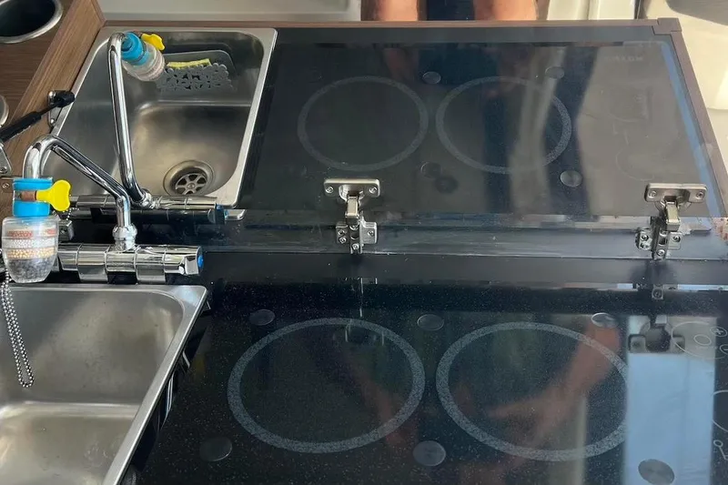 Slide: The Image of 2024 Jeanneau NC Weekender 895 kitchen with sink and glass-covered stove. - 14