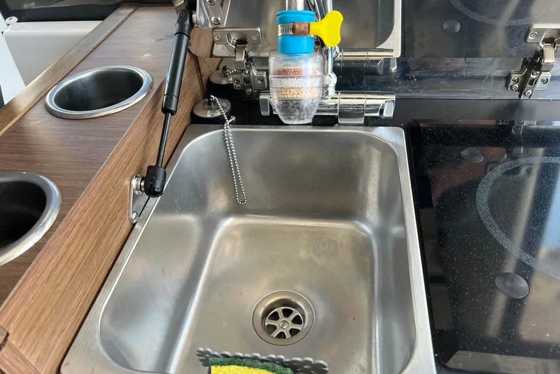 Slide: The Image of 2024 Jeanneau NC Weekender 895 kitchen sink with modern fixtures and wooden countertop. - 15