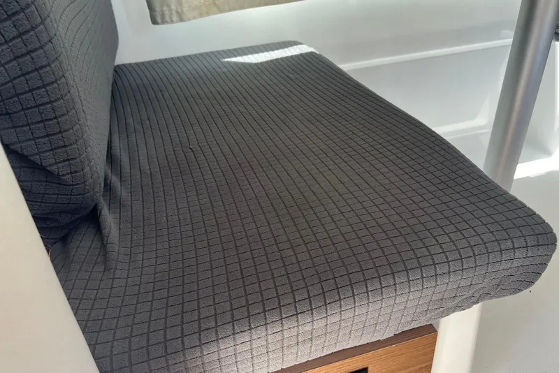 Slide: The Image of 2024 Jeanneau NC Weekender 895 interior seat with textured dark fabric. - 18