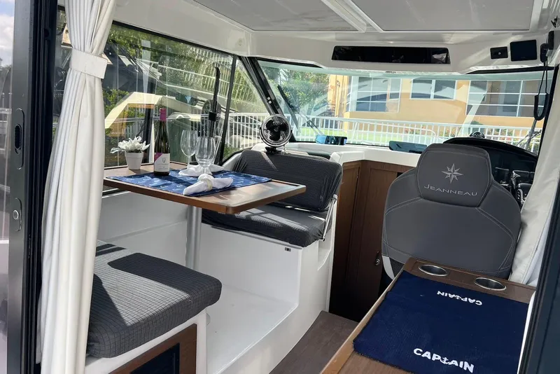 Slide: The Image of 2024 Jeanneau NC Weekender 895 interior with dining area and captain's seat. - 25