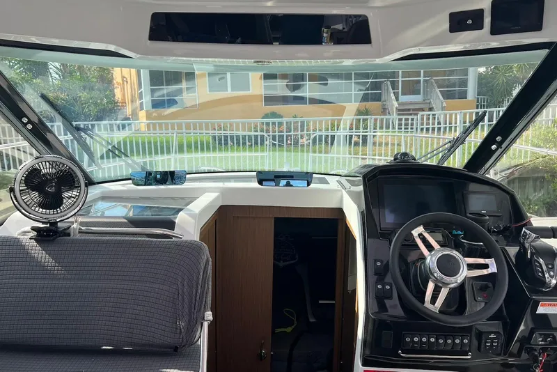 Slide: The Image of 2024 Jeanneau NC Weekender 895 helm with modern controls and panoramic view. - 28