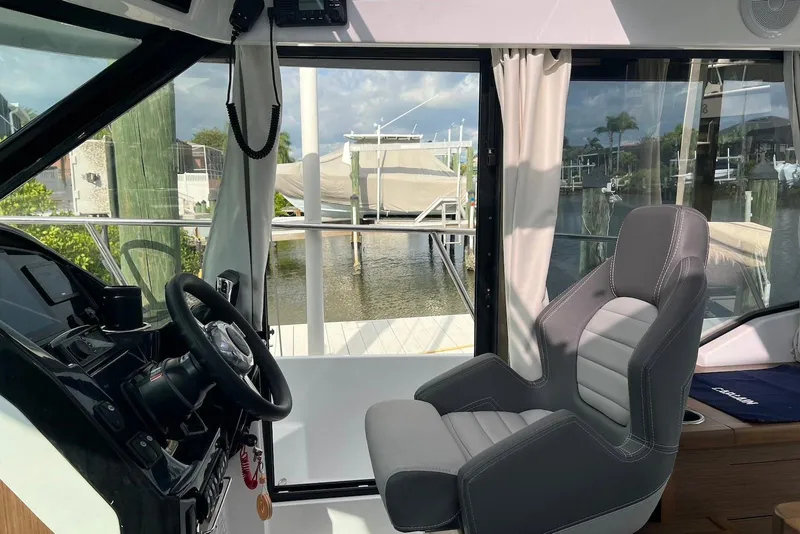 Slide: The Image of 2024 Jeanneau NC Weekender 895 interior with helm and seating, dock view. - 30