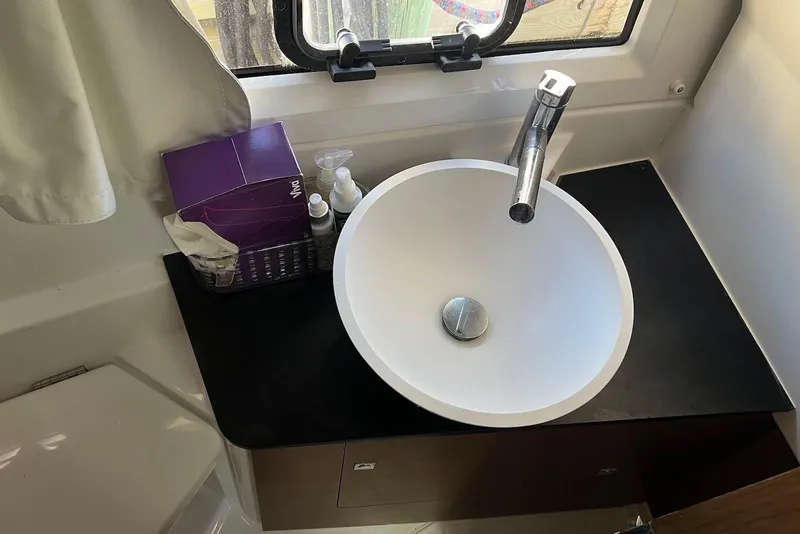 Slide: The Image of 2024 Jeanneau NC Weekender 895 bathroom sink with toiletries and window view. - 38