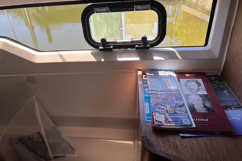 Slide: The Image of Interior of 2024 Jeanneau NC Weekender 895 with brochures by a window. - 39