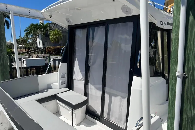 Slide: The Image of 2024 Jeanneau NC Weekender 895 boat with seating area and sliding glass doors. - 5
