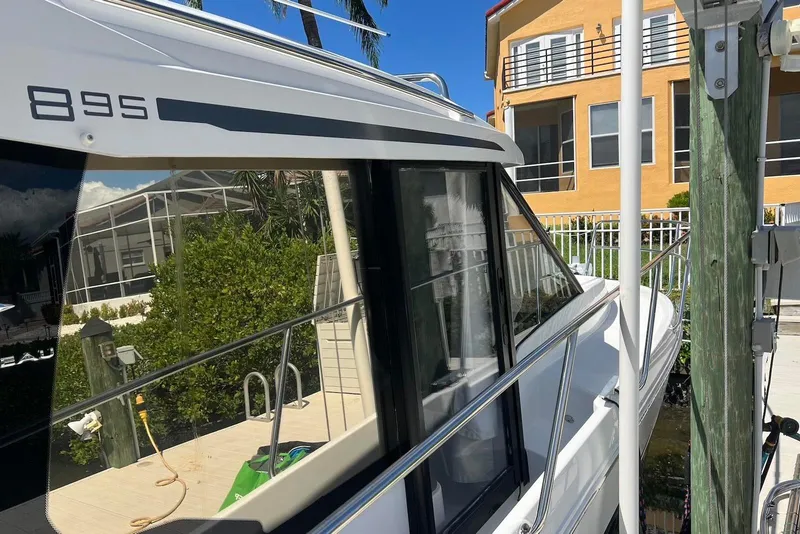 Slide: The Image of 2024 Jeanneau NC Weekender 895 docked near a waterfront home. - 7