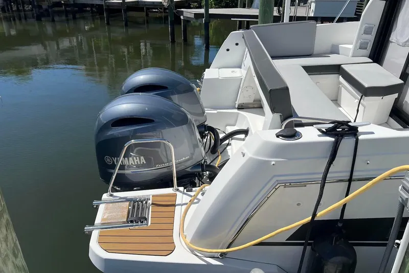 Slide: The Image of 2024 Jeanneau NC Weekender 895 with dual Yamaha outboard engines docked by the water. - 9