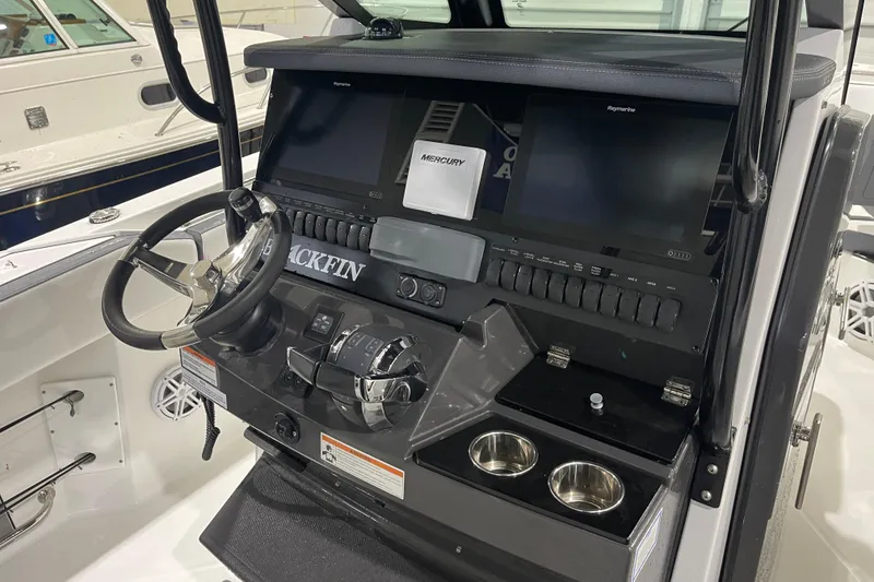 Slide: The Image of 2019 Blackfin 272 CC boat dashboard with steering wheel and dual screens. - 17