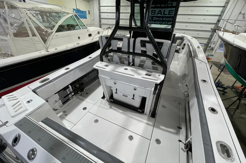 Slide: The Image of 2019 Blackfin 272 CC boat interior, showcasing spacious deck and seating in a showroom. - 19
