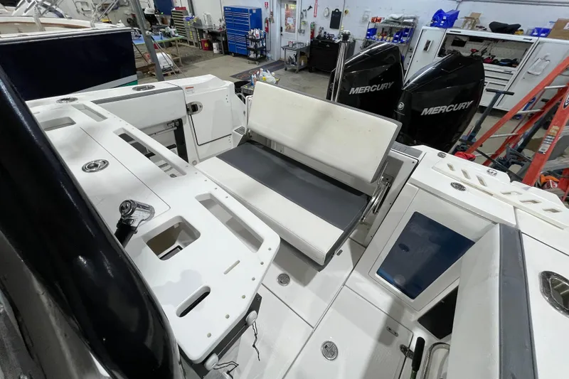 Slide: The Image of 2019 Blackfin 272 CC boat interior with seating and Mercury engines in a workshop. - 21