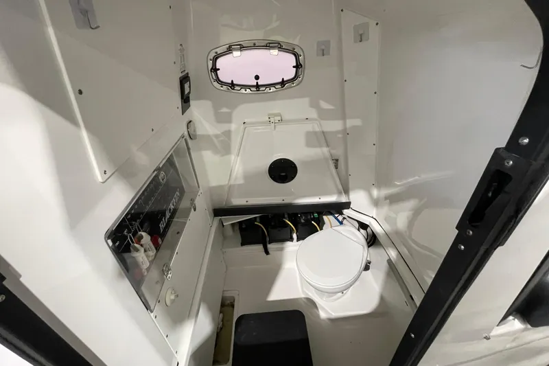 Slide: The Image of 2019 Blackfin 272 CC boat interior with compact marine toilet and control panel. - 25