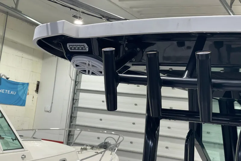 Slide: The Image of 2019 Blackfin 272 CC boat detail in a garage, showcasing rod holders and speaker. - 41