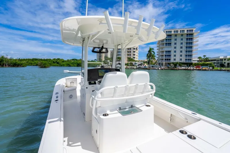 Slide: The Image of 2021 Regulator 26XO boat on water, with modern console and seating, near waterfront buildings. - 20