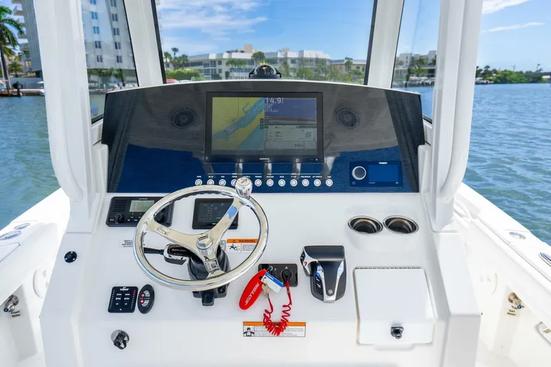 Slide: The Image of 2021 Regulator 26XO boat dashboard with steering wheel and navigation display. - 25