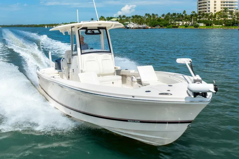 Slide: The Image of 2021 Regulator 26XO boat cruising on a sunny day in a scenic waterway. - 3