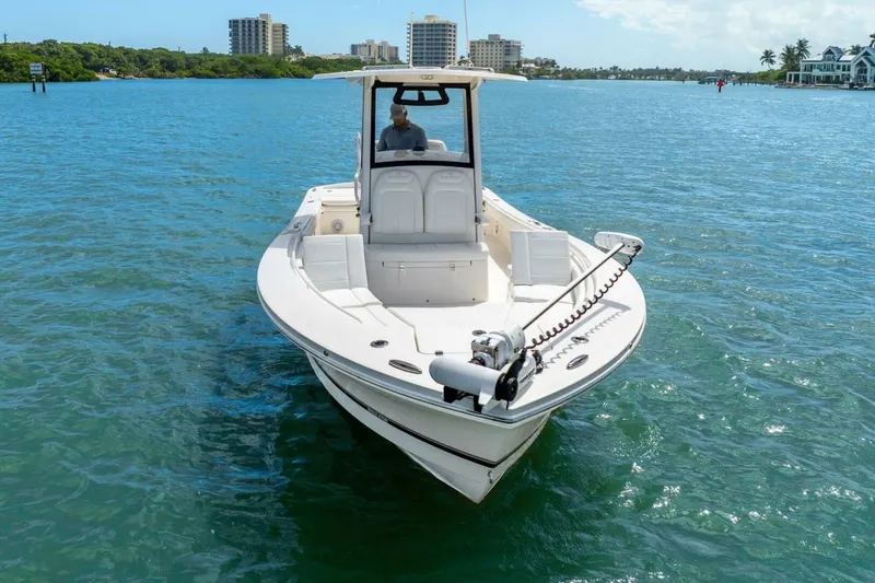 Slide: The Image of 2021 Regulator 26XO boat on clear blue water with cityscape background. - 8