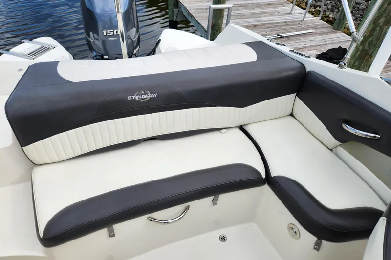 Slide: The Image of 2017 Stingray 214 LR boat interior with cushioned seating and Yamaha 150 engine. - 10