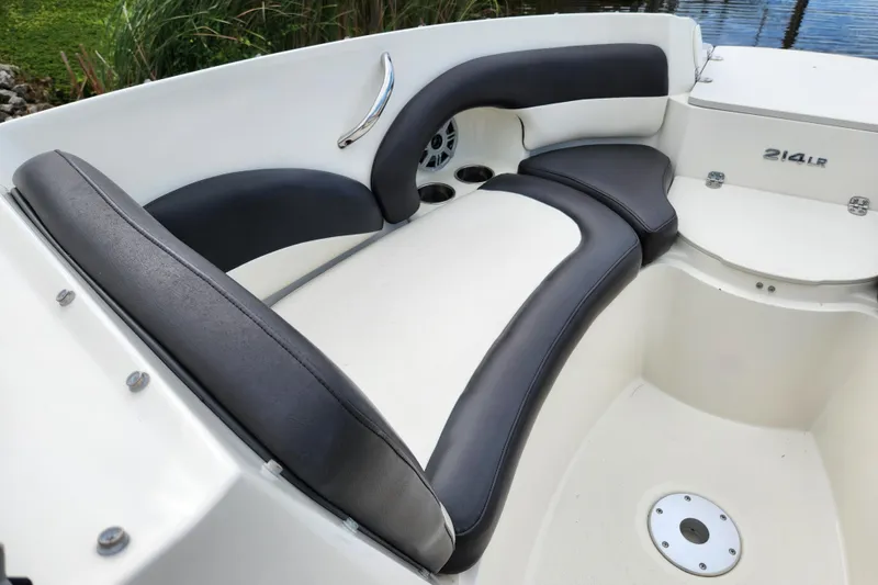 Slide: The Image of 2017 Stingray 214 LR boat interior with cushioned seating and cup holders. - 14