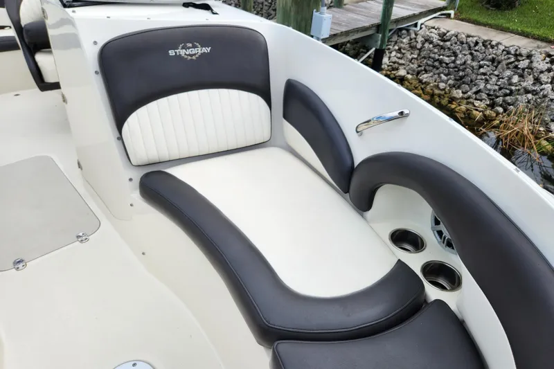 Slide: The Image of 2017 Stingray 214 LR boat interior with cushioned seating and cup holders. - 16