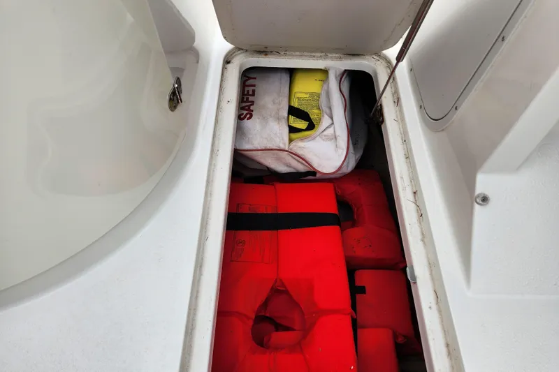 Slide: The Image of Storage compartment in a 2017 Stingray 214 LR boat with life jackets and safety gear. - 19
