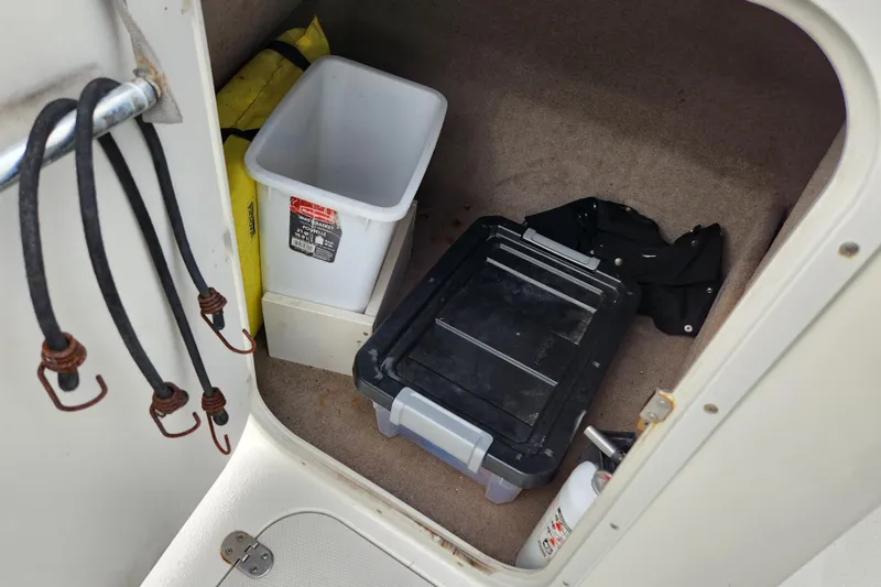 Slide: The Image of Storage compartment in 2017 Stingray 214 LR boat with bins and hooks. - 20