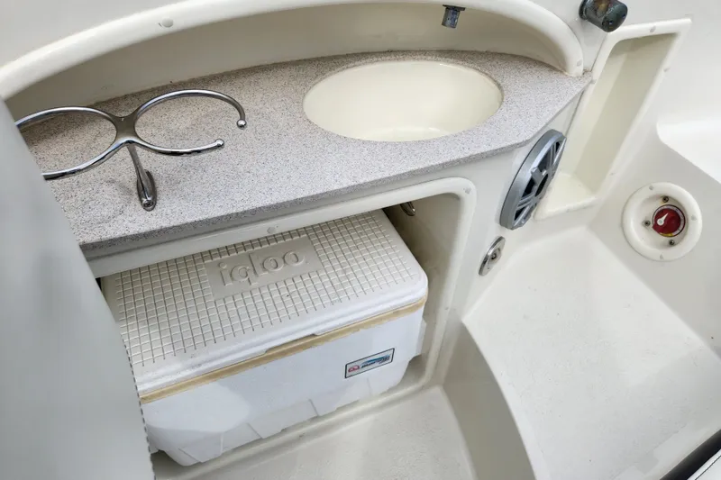 Slide: The Image of 2017 Stingray 214 LR boat interior with sink, cooler, and cup holder. - 21