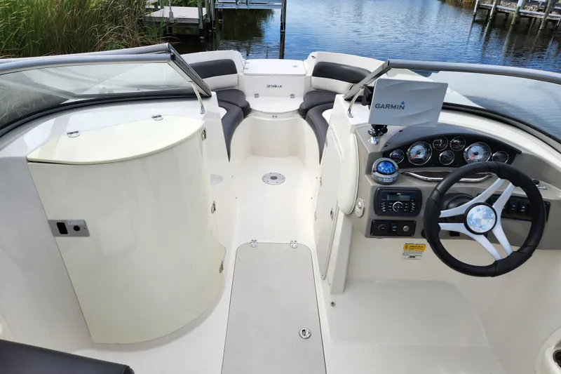 Slide: The Image of 2017 Stingray 214 LR boat interior with steering wheel, Garmin navigation, and seating. - 4